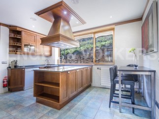 This stunning kitchen boasts a large island with granite countertops and ample wooden cabinetry, perfect for both cooking and entertaining.