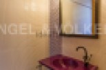 This stylish bathroom boasts a unique purple sink and dark metal stand, adding a touch of modern elegance.