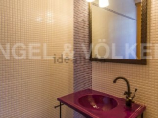 This stylish bathroom boasts a unique purple sink and dark metal stand, adding a touch of modern elegance.