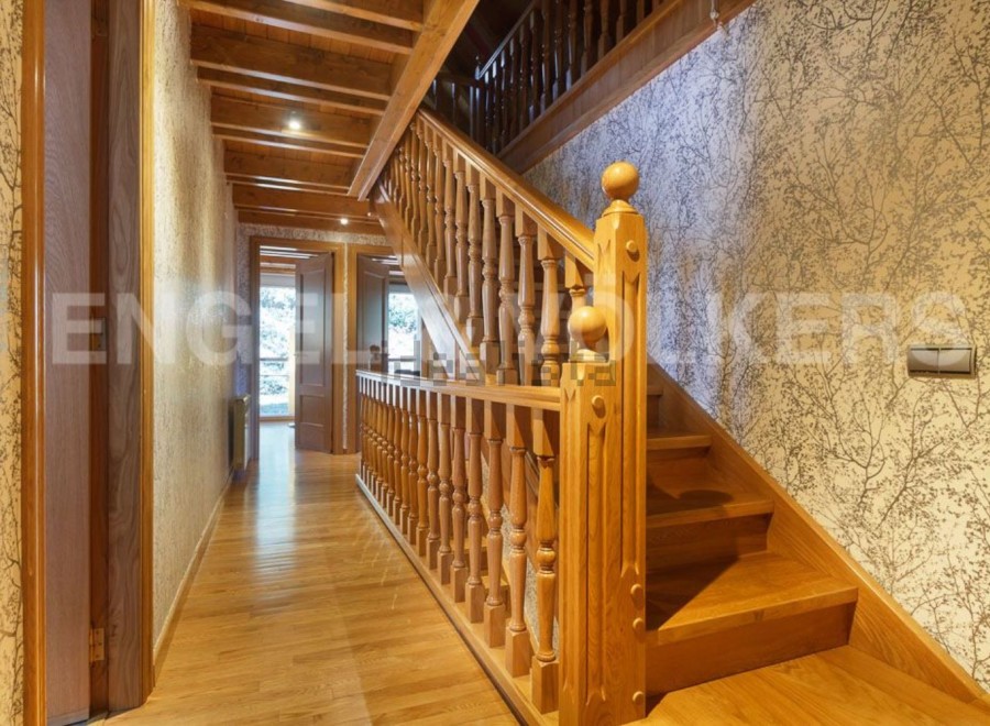 This stunning property boasts a grand wooden staircase, showcasing intricate detailing and craftsmanship.