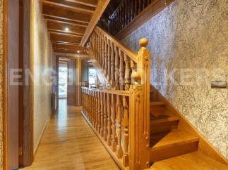 This stunning property boasts a grand wooden staircase, showcasing intricate detailing and craftsmanship.