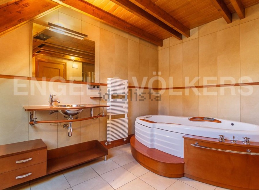 This luxurious bathroom boasts a spacious jacuzzi tub perfect for relaxation, complemented by a sleek, modern sink and vanity.