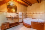 This luxurious bathroom boasts a spacious jacuzzi tub perfect for relaxation, complemented by a sleek, modern sink and vanity.