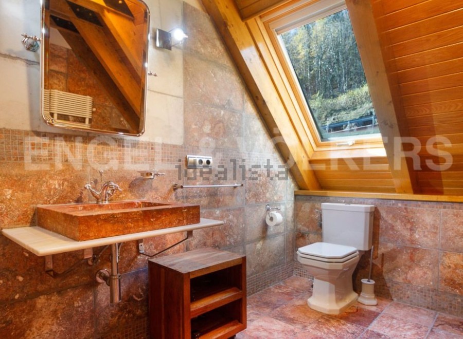 This stunning bathroom boasts a unique, rustic-chic design with a gorgeous stone sink and toilet.