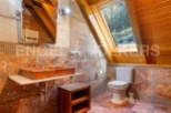 This stunning bathroom boasts a unique, rustic-chic design with a gorgeous stone sink and toilet.