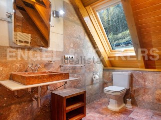 This stunning bathroom boasts a unique, rustic-chic design with a gorgeous stone sink and toilet.