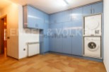 This stunning property boasts a laundry room complete with modern washer and dryer, tucked neatly into stylish blue cabinetry.