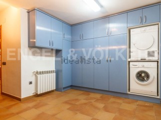 This stunning property boasts a laundry room complete with modern washer and dryer, tucked neatly into stylish blue cabinetry.