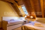 Cozy attic bedroom with wooden beams and skylights.