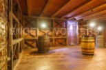 This stunning wine cellar boasts a rustic-chic design with exposed wooden beams and terracotta tile flooring.