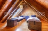 Charming attic bedroom with twin beds, wooden beams, and plenty of natural light.