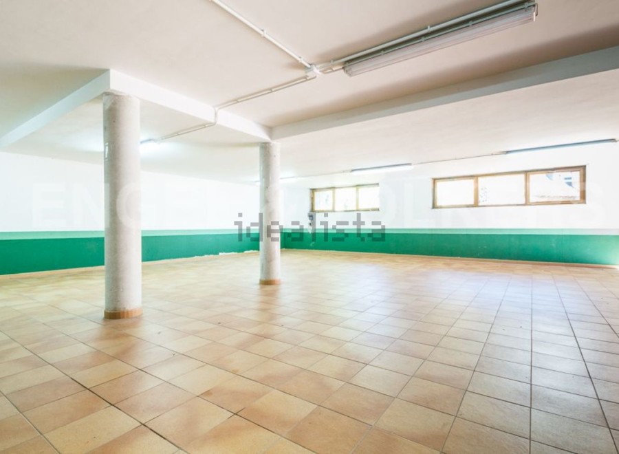 Spacious basement with tiled flooring and large windows, offering ample natural light.