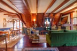 This stunning chalet boasts a spacious open-plan living area with exposed wooden beams and a cozy fireplace.
