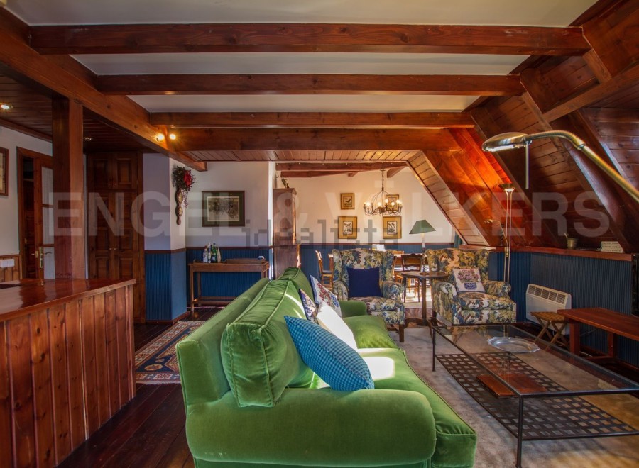 This stunning chalet boasts a spacious open-plan living area with exposed wooden beams, creating a warm and inviting atmosphere.