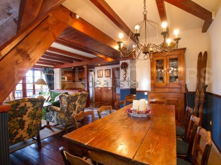 This charming chalet boasts a spacious dining area with a rustic wooden table, perfect for family gatherings.