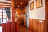 Cozy mountain chalet kitchen with wooden finishes and stainless steel appliances.