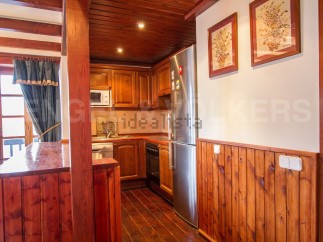 Cozy mountain chalet kitchen with wooden finishes and stainless steel appliances.