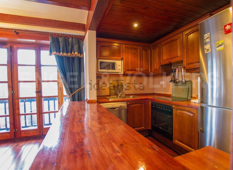 This charming kitchen boasts a rustic wooden design with ample counter space, perfect for cooking and entertaining.