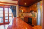This charming kitchen boasts a rustic wooden design with ample counter space, perfect for cooking and entertaining.
