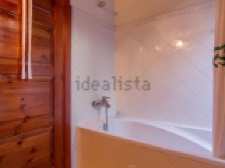 Charming bathroom with wooden ceiling and tiled walls.