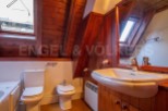Charming attic bathroom with wooden beams and sloped ceilings.