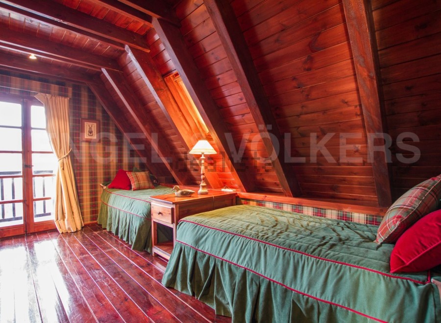 Cozy A-frame cabin with wood-paneled walls and ceilings.