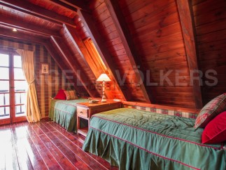 Cozy A-frame cabin with wood-paneled walls and ceilings.
