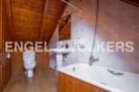 Charming attic bathroom with wooden finishes and a bathtub.