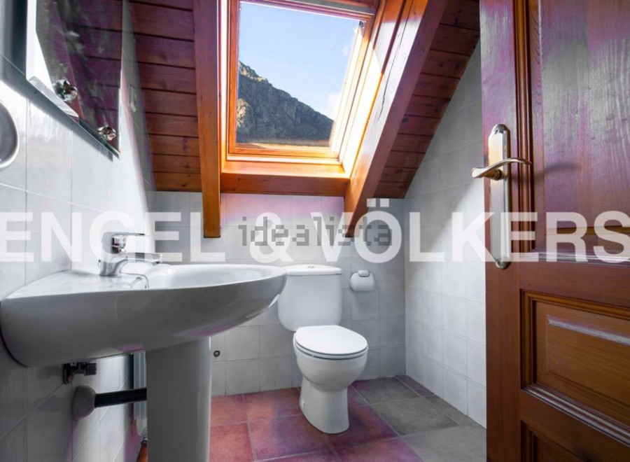 Charming attic bathroom with skylight offering mountain views.
