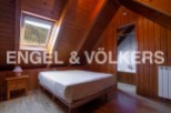 Cozy attic bedroom with wooden walls and a skylight offering stunning mountain views.