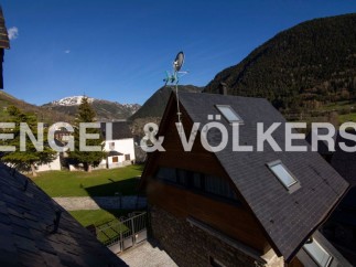 Mountain view home with slate roof and large windows.
