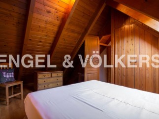 Charming attic bedroom with wooden beams and built-in wardrobes.