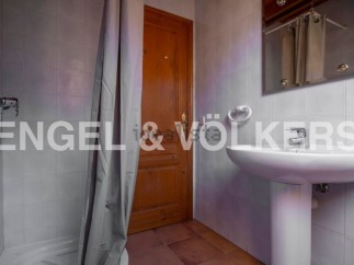 Charming bathroom with shower stall and pedestal sink.