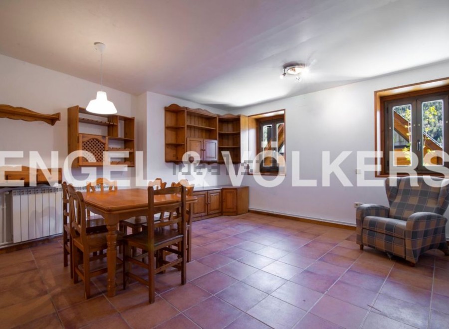Charming rustic apartment featuring a spacious dining area with wooden furniture and built-in shelving.