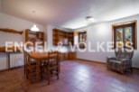 Charming rustic apartment featuring a spacious dining area with wooden furniture and built-in shelving.