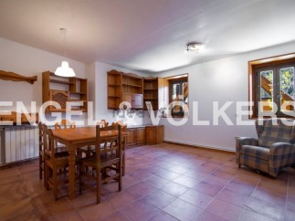 Charming rustic apartment featuring a spacious dining area with wooden furniture and built-in shelving.