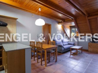 Cozy attic apartment with wooden beams and tiled floors.