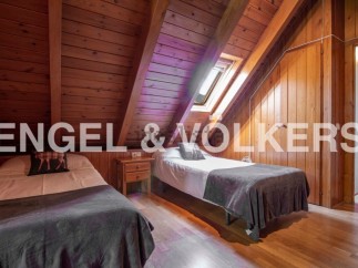 Charming attic bedroom with twin beds and wooden beams.