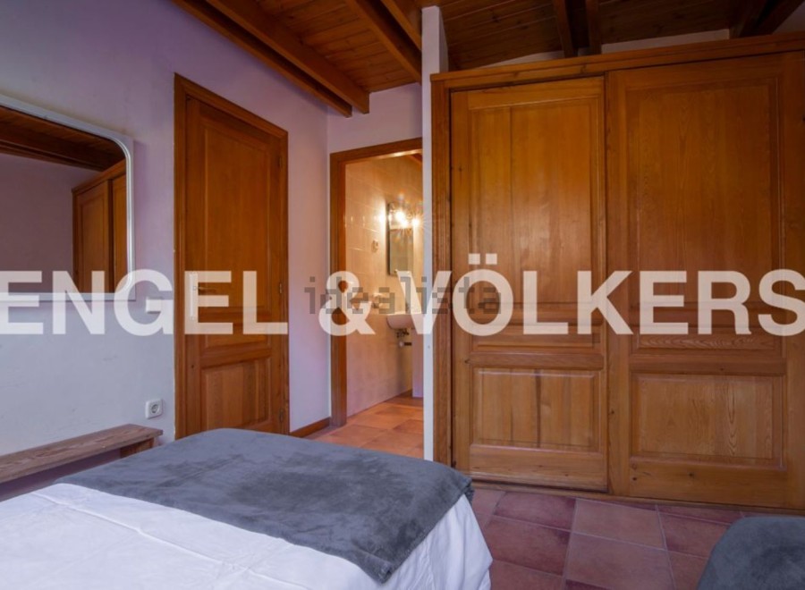Charming bedroom with wooden floors and built-in wardrobe.