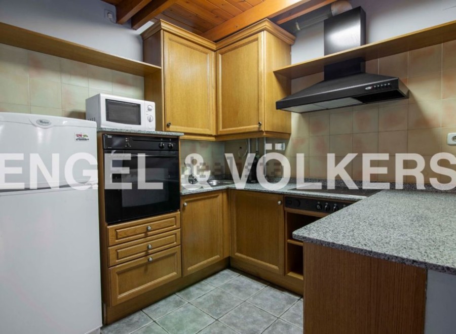 Cozy kitchen with wooden cabinets, granite countertops, and integrated appliances.
