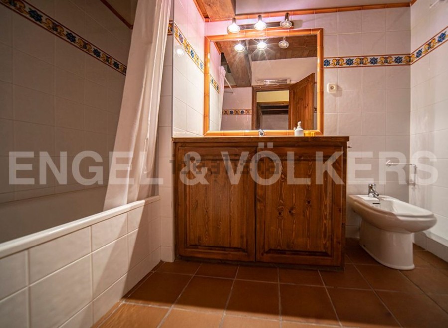 Charming bathroom with a classic wooden vanity and a bathtub.