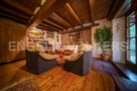 Cozy living room with wooden beams, hardwood floors, and comfortable armchairs.