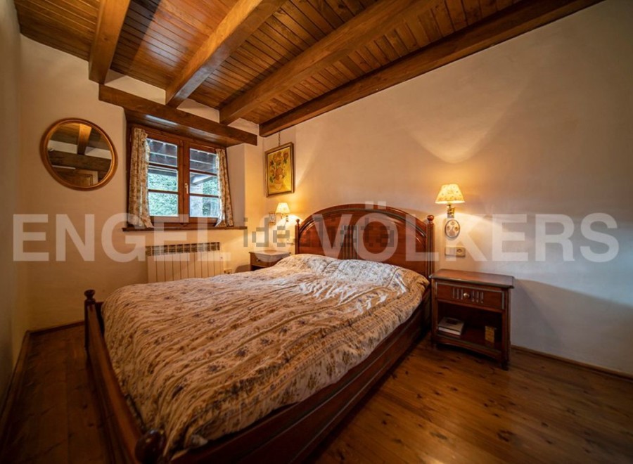 Cozy wooden bedroom with a double bed, nightstands, and warm lighting.