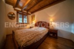Cozy wooden bedroom with a double bed, nightstands, and warm lighting.