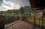 Mountain view balcony with wooden deck and railing.