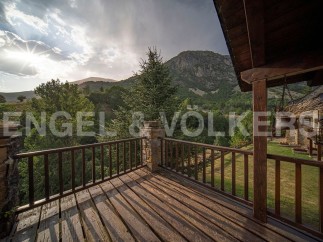 Mountain view balcony with wooden deck and railing.