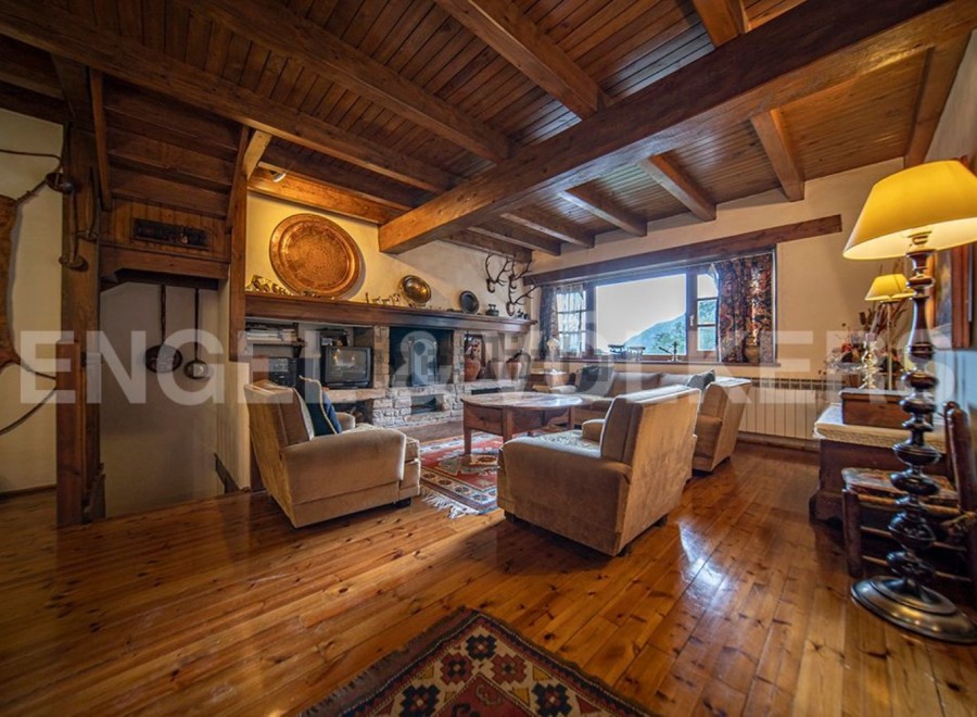 Rustic mountain home with stunning wooden beams, hardwood floors, and a cozy fireplace.