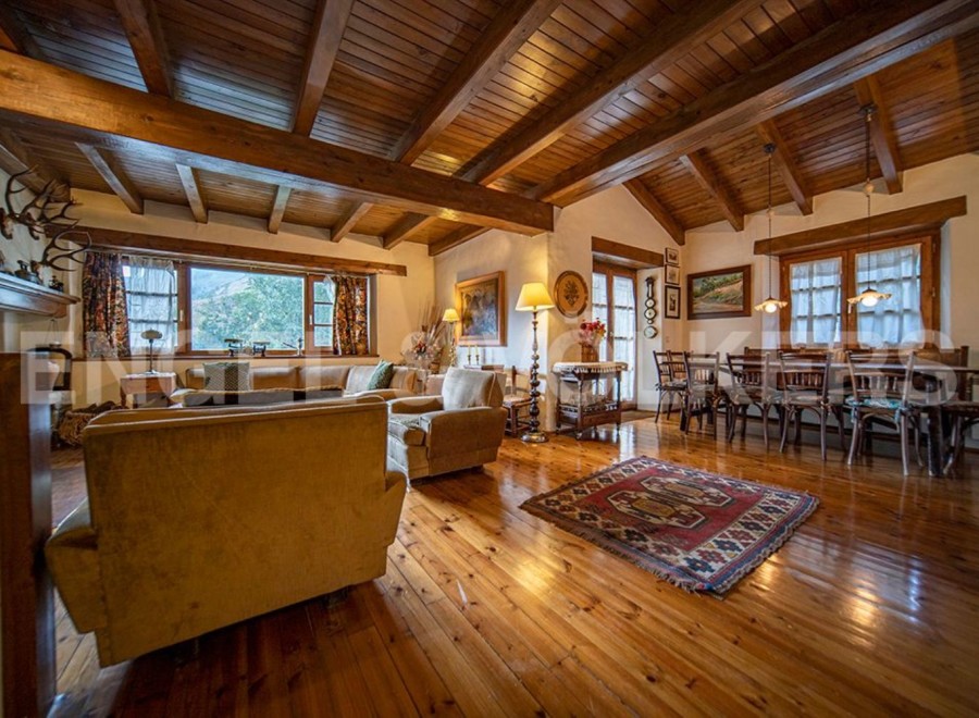 This stunning property boasts a spacious open-plan living area with high wooden beamed ceilings and large windows offering breathtaking views.