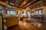 This stunning property boasts a spacious open-plan living area with high wooden beamed ceilings and large windows offering breathtaking views.