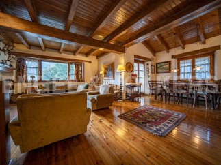 This stunning property boasts a spacious open-plan living area with high wooden beamed ceilings and large windows offering breathtaking views.